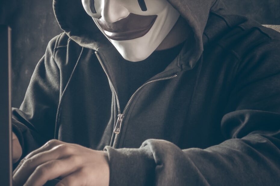 a person wearing a mask using a laptop